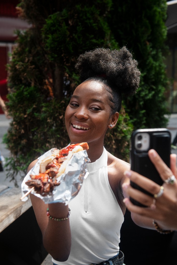 Content creator filming herself at a food festival